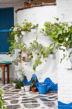 Traditional white Greek house with flowers on  walls