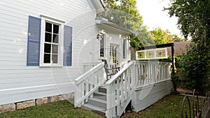 a white house with blue shuttered windows, and green grass in front