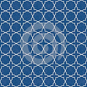 Traditional white quatrefoil lattice design on watercolor style textured blue background. Seamless vector pattern