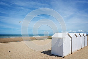 Traditional white wooden beach cabins on the beach of Villers, Normandy France
