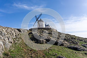 Traditional whitewashed Spanish windmills in La Mancha on a hilltop above Consuegra