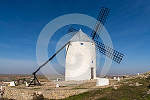 Traditional whitewashed Spanish windmills in La Mancha on a hilltop above Consuegra