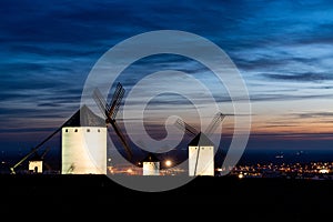 Traditional whitewshed Spanish windmills in La Mancha just after sunset under a cool blue night sky