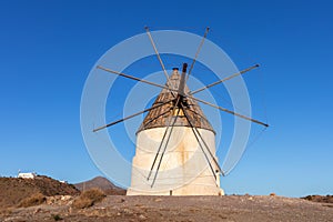 Traditional windmill in the countryside, old mill used to grind wheat flour or other raw materials using the wind energy.