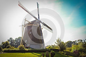 Traditional windmill in Holland on bright summer sunny day. Sightseeing in the Netherlands.