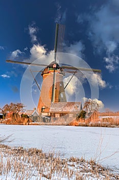 Traditional windmills and frozen canal, blue sky, Kinderdijk, Netherlands