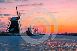 Traditional windmills on ice Kinderdijk, Netherlands at dawn