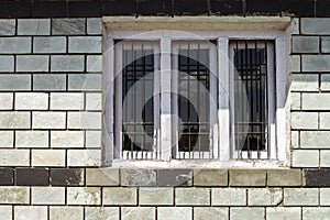 Traditional window along brick wall with sky cloud reflection.
