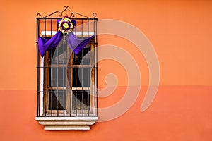 Traditional window on orange wall with semana santa ribbon decoration in Antigua, Guatemala photo