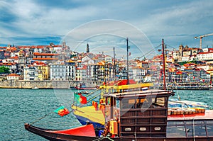 Traditional wine boats in water of Douro River and Ribeira district embankment with colorful buildings