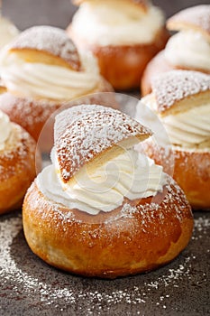 Traditional winter sweet Semla semlor or fastlagsbulle flavored with cardamom, filled with almond paste and whipped cream closeup