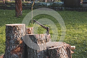 Traditional wooden axe with an iron hilt stuck into a wooden trunk. Outdoor life of a woodcutter