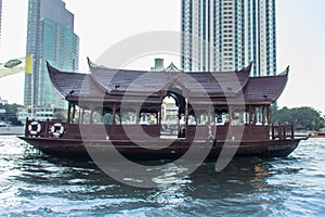 Traditional wooden boat with restaurant on the Chao Phraya river cruising tour. River view of the tourist boat takes visitors for