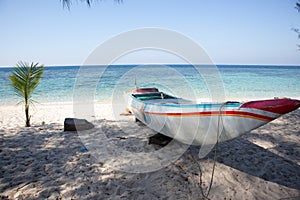 a traditional wooden boat sitting on top of a sandy beach