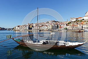Traditional wooden boats at the Douro river for transporting wine with city on the background of Porto city, Portugal.