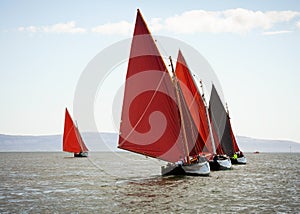 Traditional wooden boats with red sail.