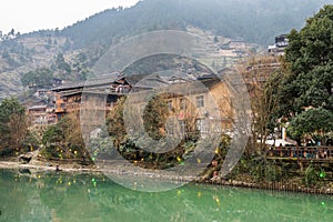 Traditional wooden building cluster at the bank of river of Xijiang Qianhu Miao Village The One Thousand Household Miao Village