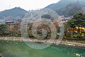 Traditional wooden building cluster at the bank of river of Xijiang Qianhu Miao Village The One Thousand Household Miao Village