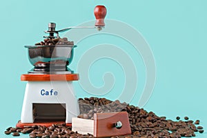 Traditional wooden coffee mill grinder over aquamarine background