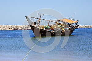 Traditional wooden dhow boat in port city of Al Ashkhara. Sultanate of Oman