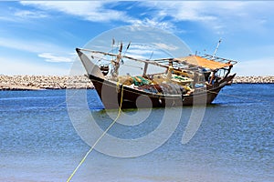 Traditional wooden dhow boat in port city of Al Ashkhara. Sultanate of Oman