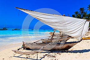 Traditional wooden dhow boats ashore on tropical sandy Nungwi beach in the Indian ocean on Zanzibar, Tanzania