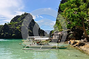 Traditional wooden filipino boats in a blue lagoon