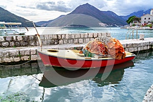 Traditional wooden fishing boat in marina harbor in city Perast, Montenegro