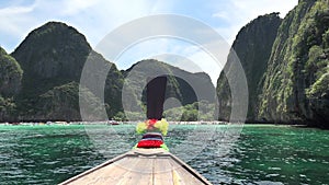 Traditional wooden long-tail boat enters Maya Bay in Phi Phi Islands, Andaman Sea, Thailand