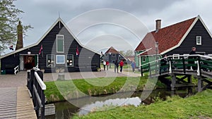 Traditional wooden mills with rotating blades by the river in old town Zaanse Schans, North Holland, Netherlands. May 15