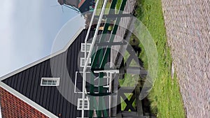 Traditional wooden mills with rotating blades by the river in old town Zaanse Schans, North Holland, Netherlands. May 15