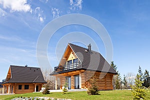 Traditional wooden mountain house on green field