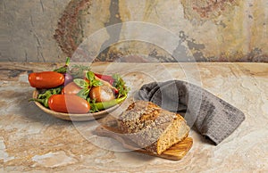 Traditional wooden plate with fresh seasonal vegetables: green pepper, tomato, onion, carrot, cucumber, basil, dill bread