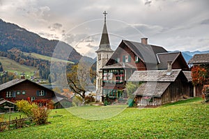 Traditional wooden residential houses on the shore of lake Grundlsee on a cloudy autumn day. Town of Grundlsee, Styria, Austria