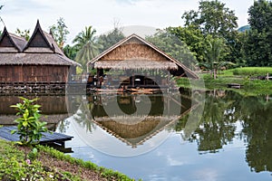 Traditional wooden thai house by canal with wood boat