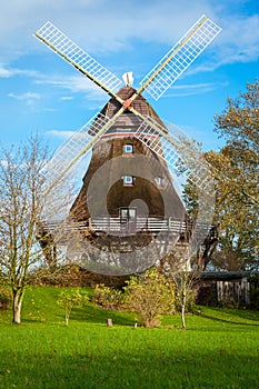 Traditional wooden windmill in a lush garden