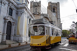 Traditional yellow tram in front of Lisbon Cathedral in Lisbon, Portugal