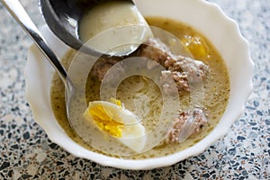 Traditional Zurek. Polish Rye Soup. Sour bread soup served with hard boiled egg and white sausage.