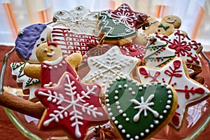 Traditionally decorated Christmas gingerbread cookies on a blass bowl