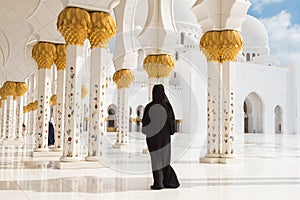 Arabic woman in black burka in Sheikh Zayed Grand Mosque, Abu Dhabi, UAE.