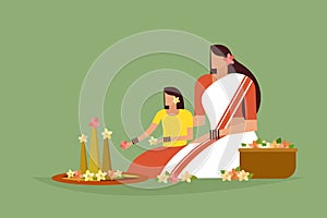 Traditionally dressed mother and daughter do floral designs on floor to celebrate Onam festival