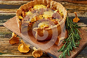 Traditonal swedish cheese and mushroom pie - quiche on the rustic kitchen background decorated with fresh rosemary