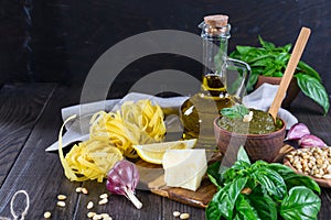 Tradizione Italiana Homemade Pesto recipe ingredients on dark table.