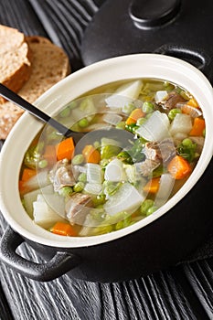 Tradtional Scottish Harvest Broth called Hotch Potch with lamb meat close-up on the table. Vertical