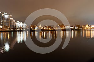 Traetskae Pradmestse or Trinity Suburb and Island of Courage and Sorrow or Ostrov Slyoz on Svisloch river bank at night. Minsk.