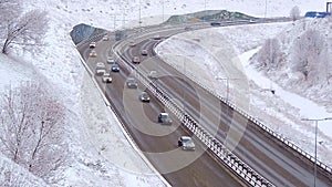 Traffic of cars on a highway at winter frosty morning in the city.