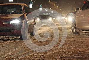 Traffic in the city cars bad weather and snow blizzard by night