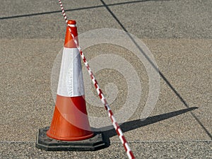 Traffic cone with barricade tape on the road