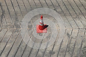 A traffic cone is placed on the concrete floor