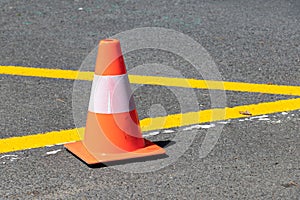 Traffic cone on the road near the yellow line